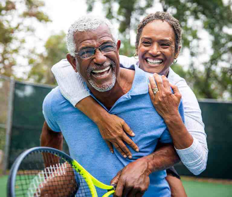 happy couple playing tennis